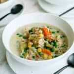 Plated bowl of Instant Pot Creamy Chicken and Rice Soup with serving spoon