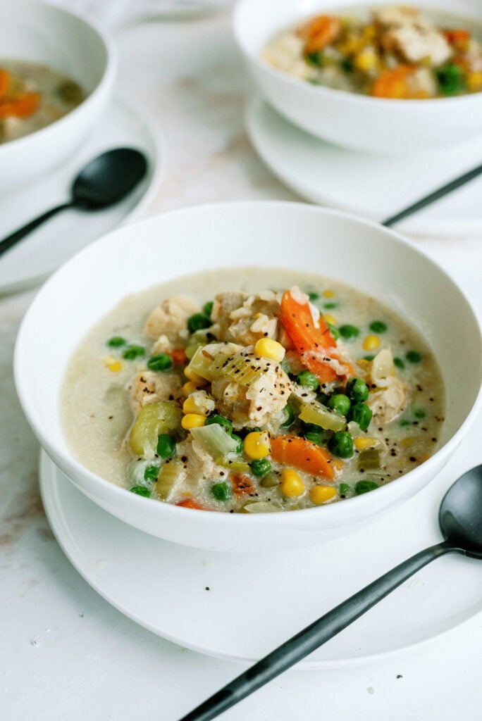 Plated bowl of Instant Pot Creamy Chicken and Rice Soup with serving spoon