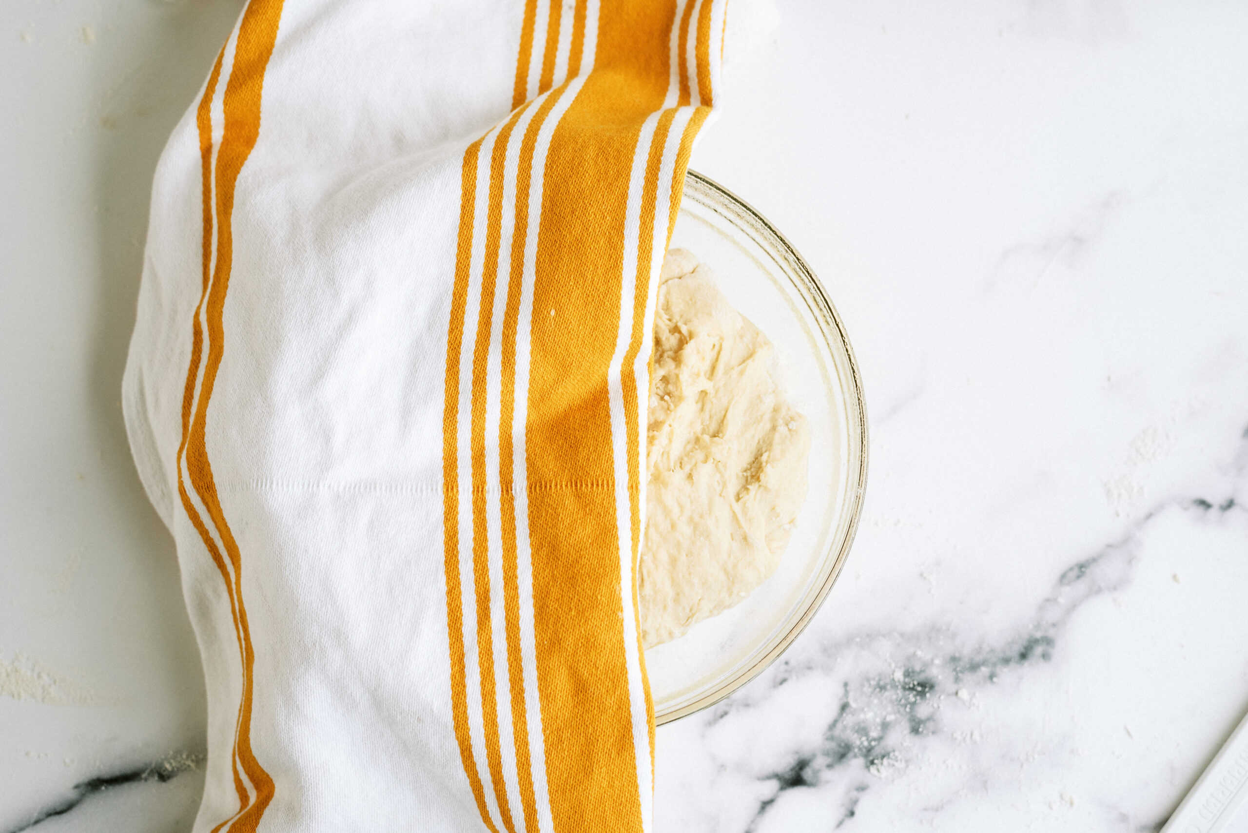 Dough rising under a towel.