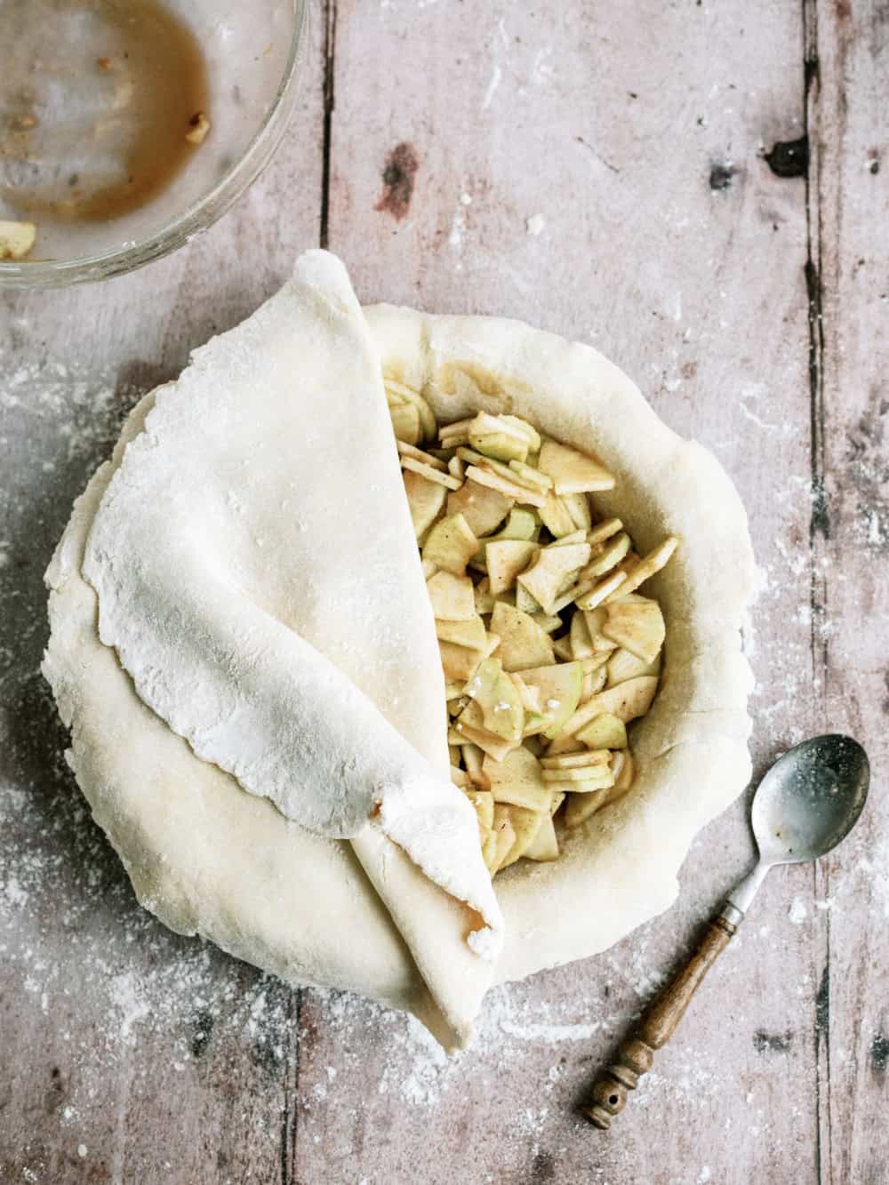 sliced apples inside pie dough to make an apple pie