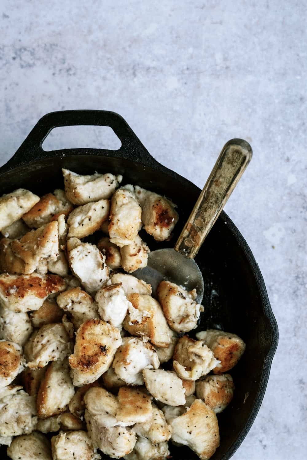 cooking chicken on a skillet with a spatula