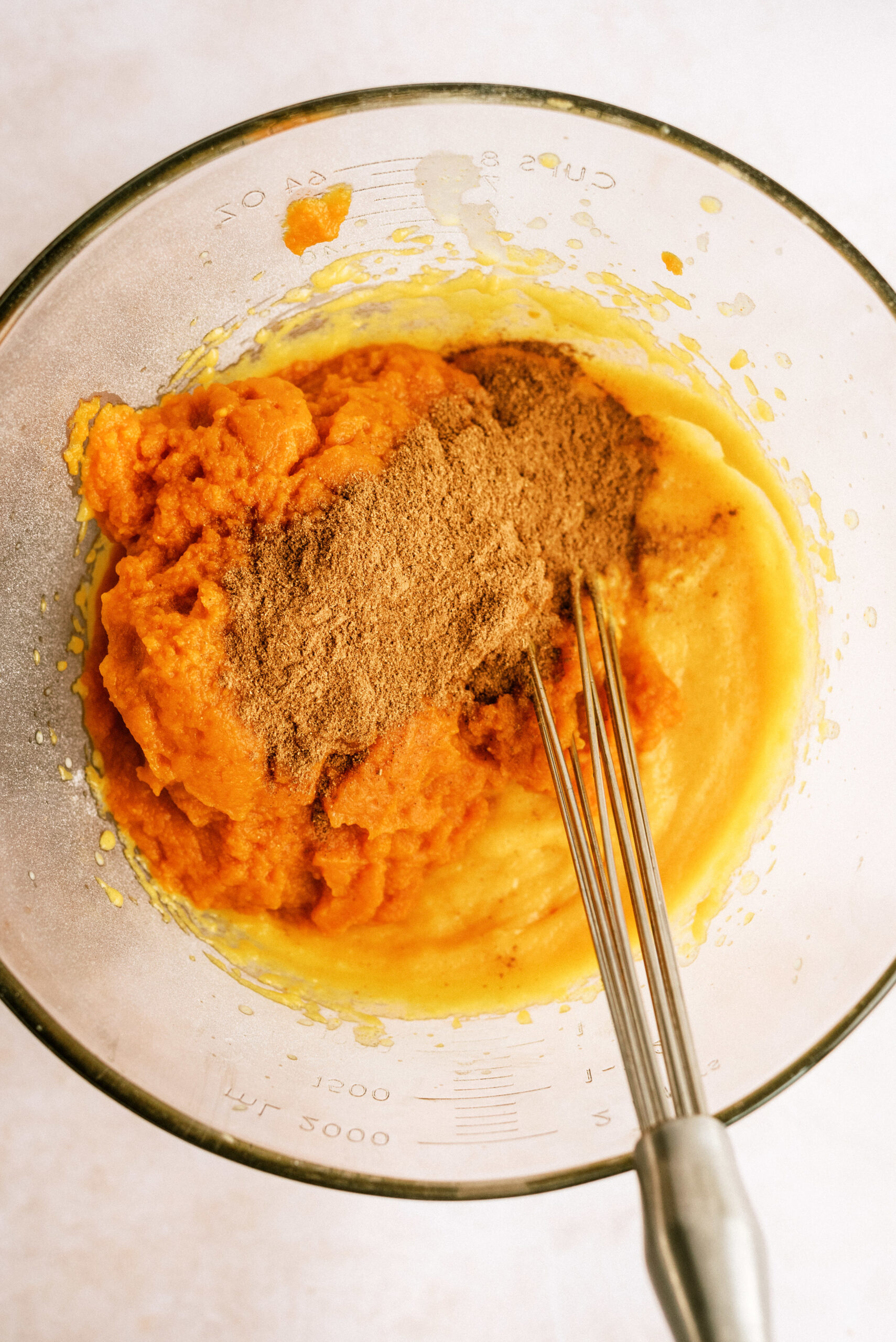 Pumpkin Puree mixed with pudding and evaporated milk in bowl