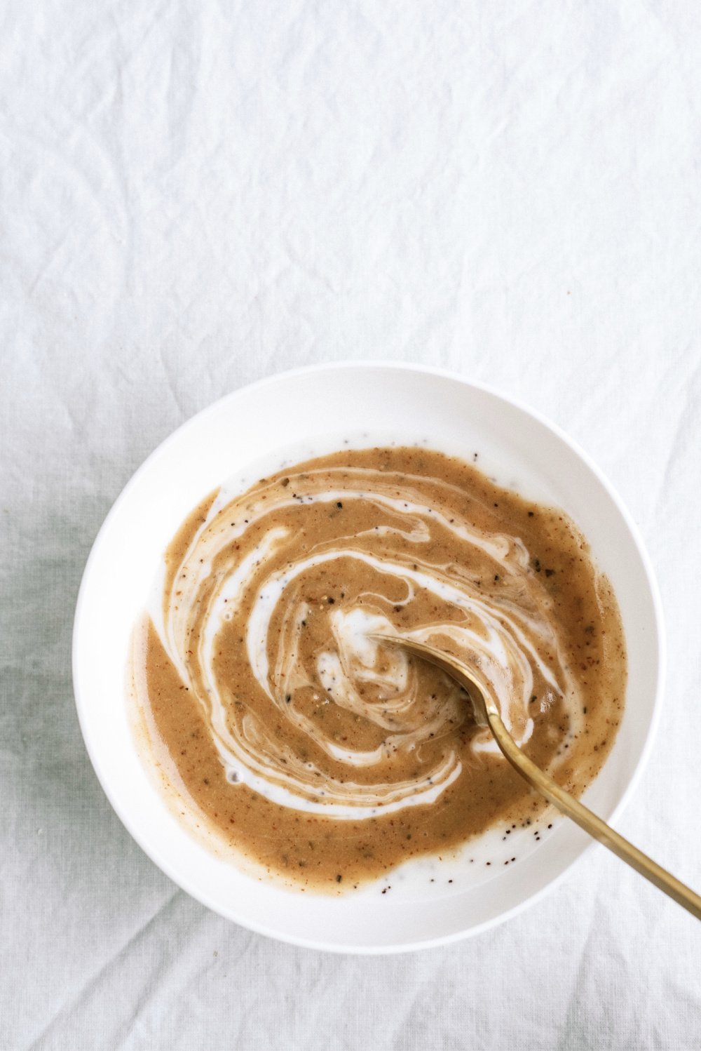 poppy seed dressing and balsamic vinaigrette swirled together in a bowl with a spoon