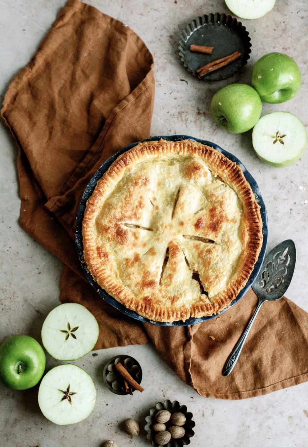 freshly baked apple pie in pie in surrounded by green apples