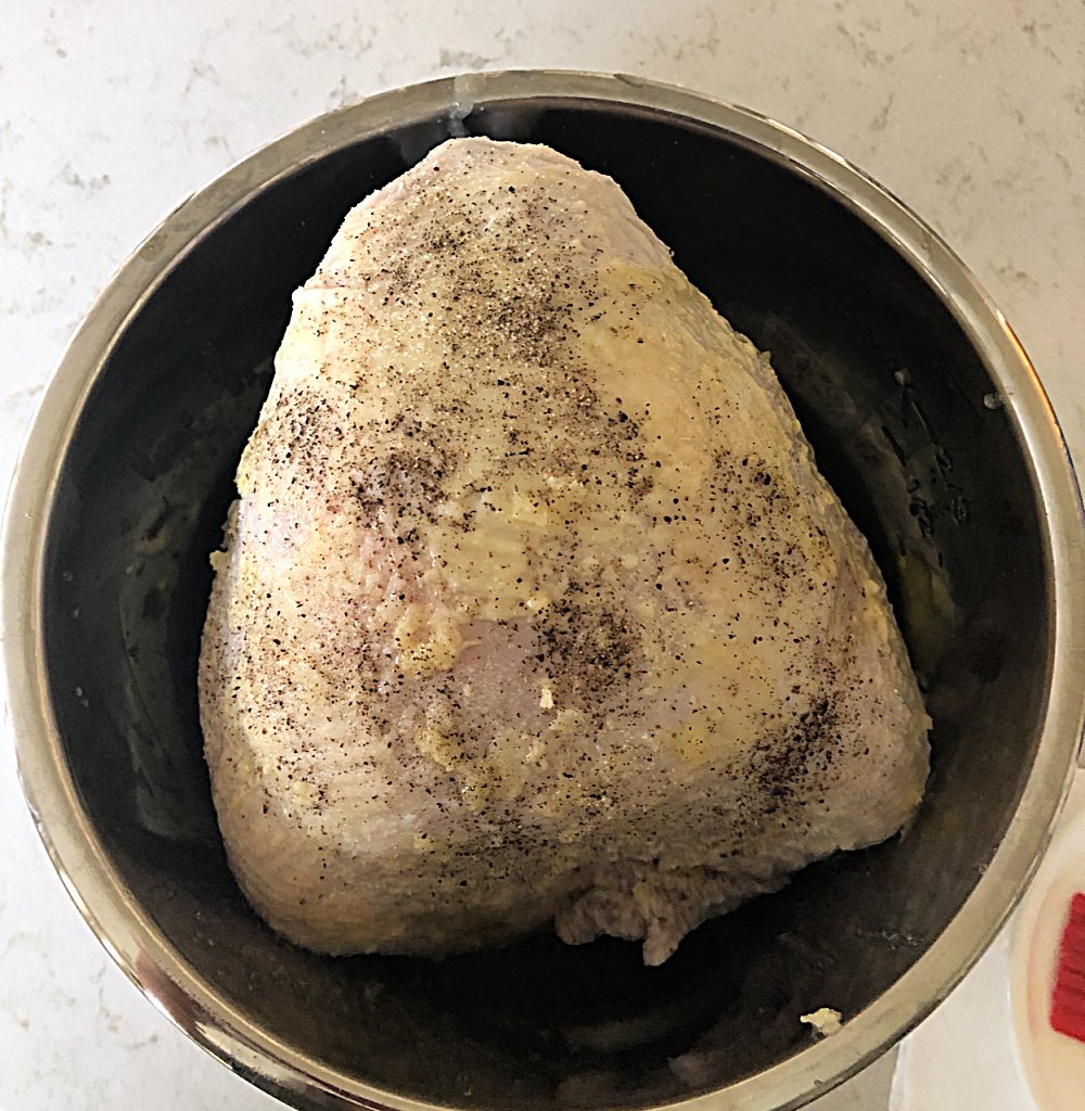 frozen turkey in instant pot brushed with butter and topped with seasonings