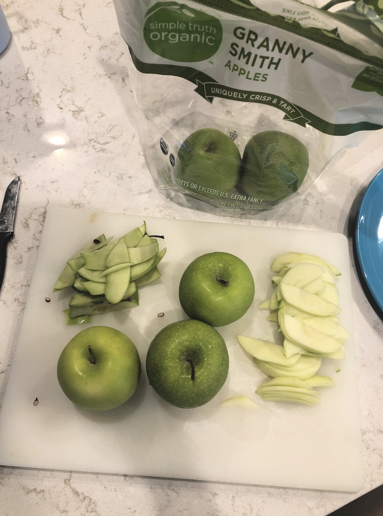 granny smith apples being peeled and sliced to go into the pie