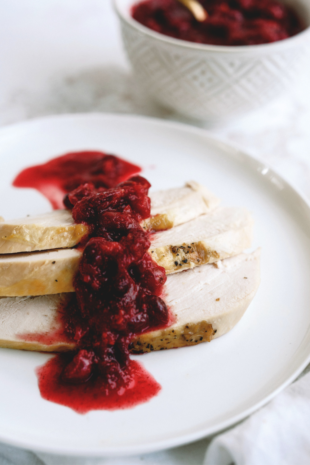 Turkey with fresh cranberry sauce on top of turkey slices