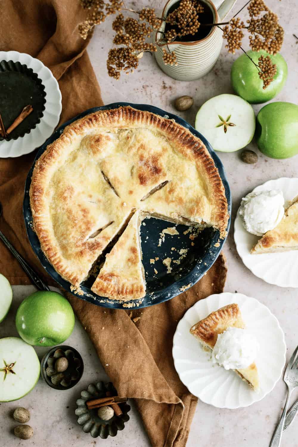 apple pie cut into slices and served on small white plates