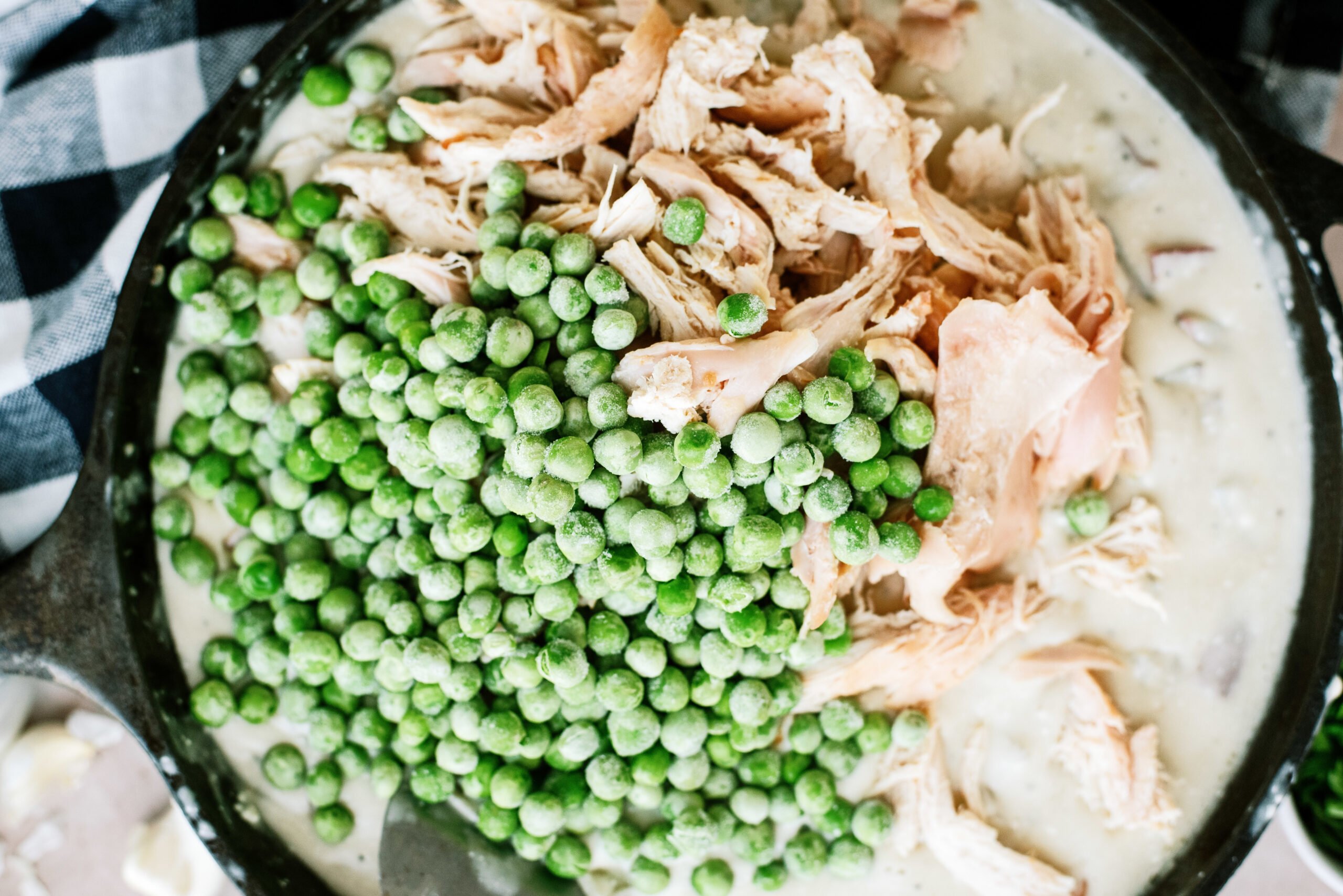 Chicken and peas added to skillet pot pie ingredients. 