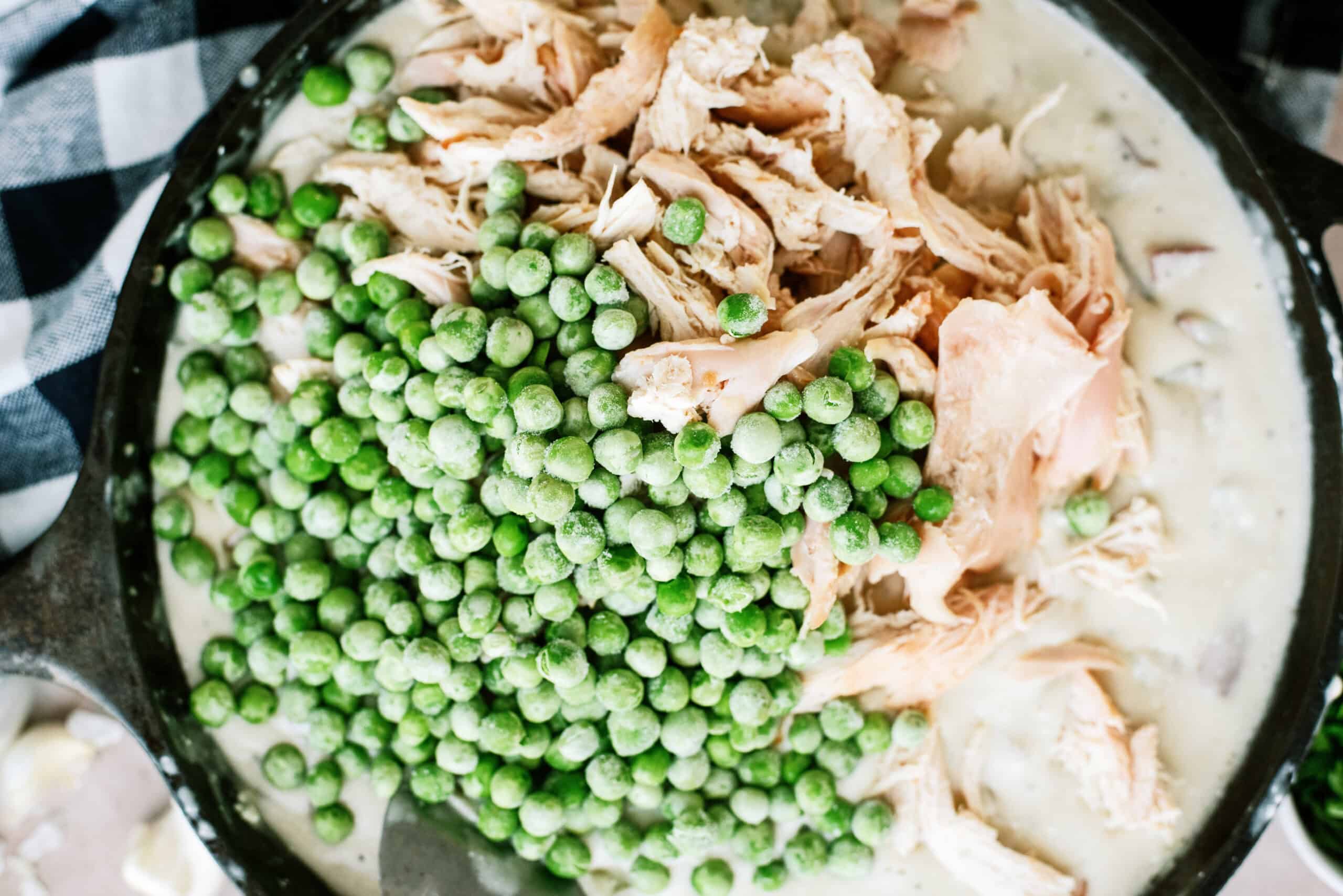Chicken and peas added to skillet pot pie ingredients.