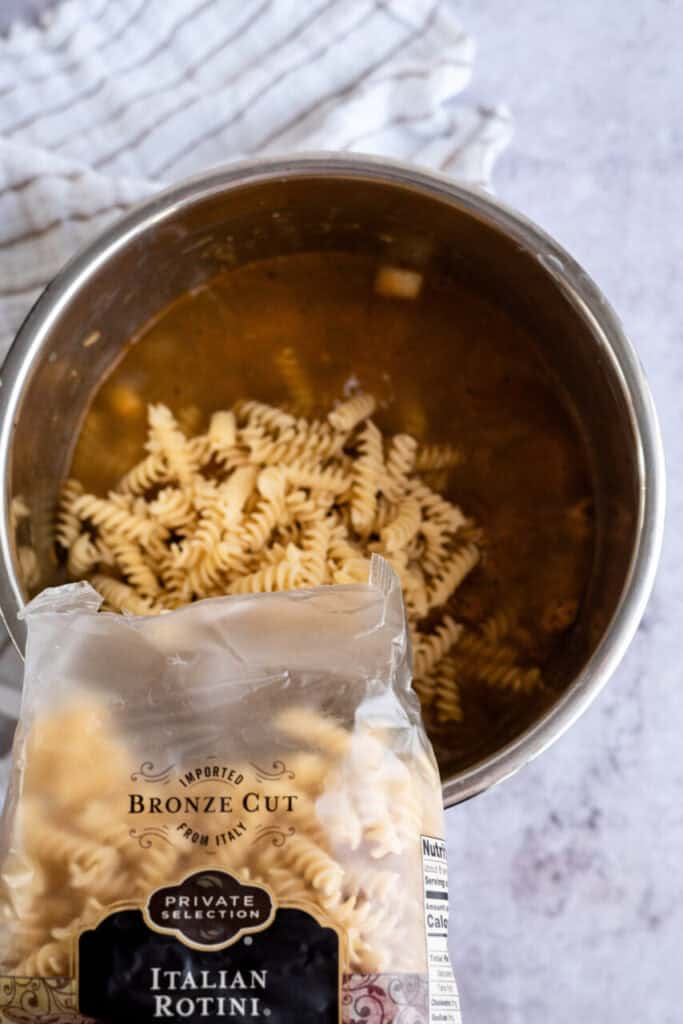Adding uncooked pasta to instant pot.