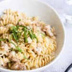 A serving of Instant Pot Cheesy Chicken and Pasta in a white bowl.