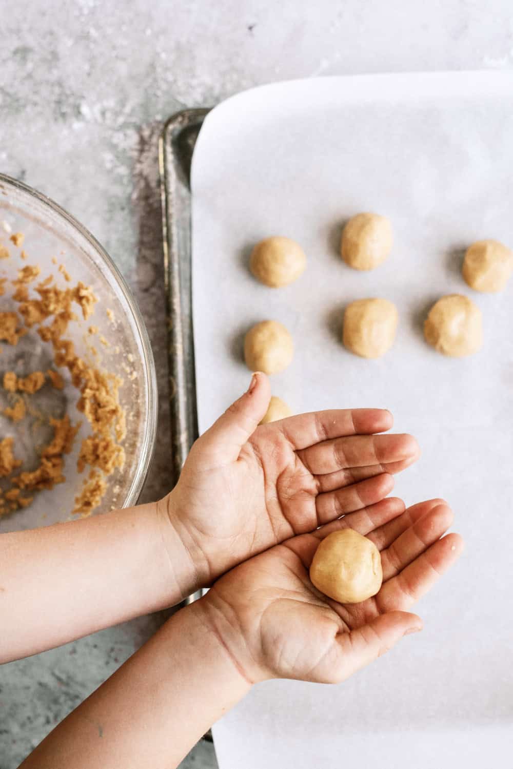 hands rolling peanut butter dough into a ball