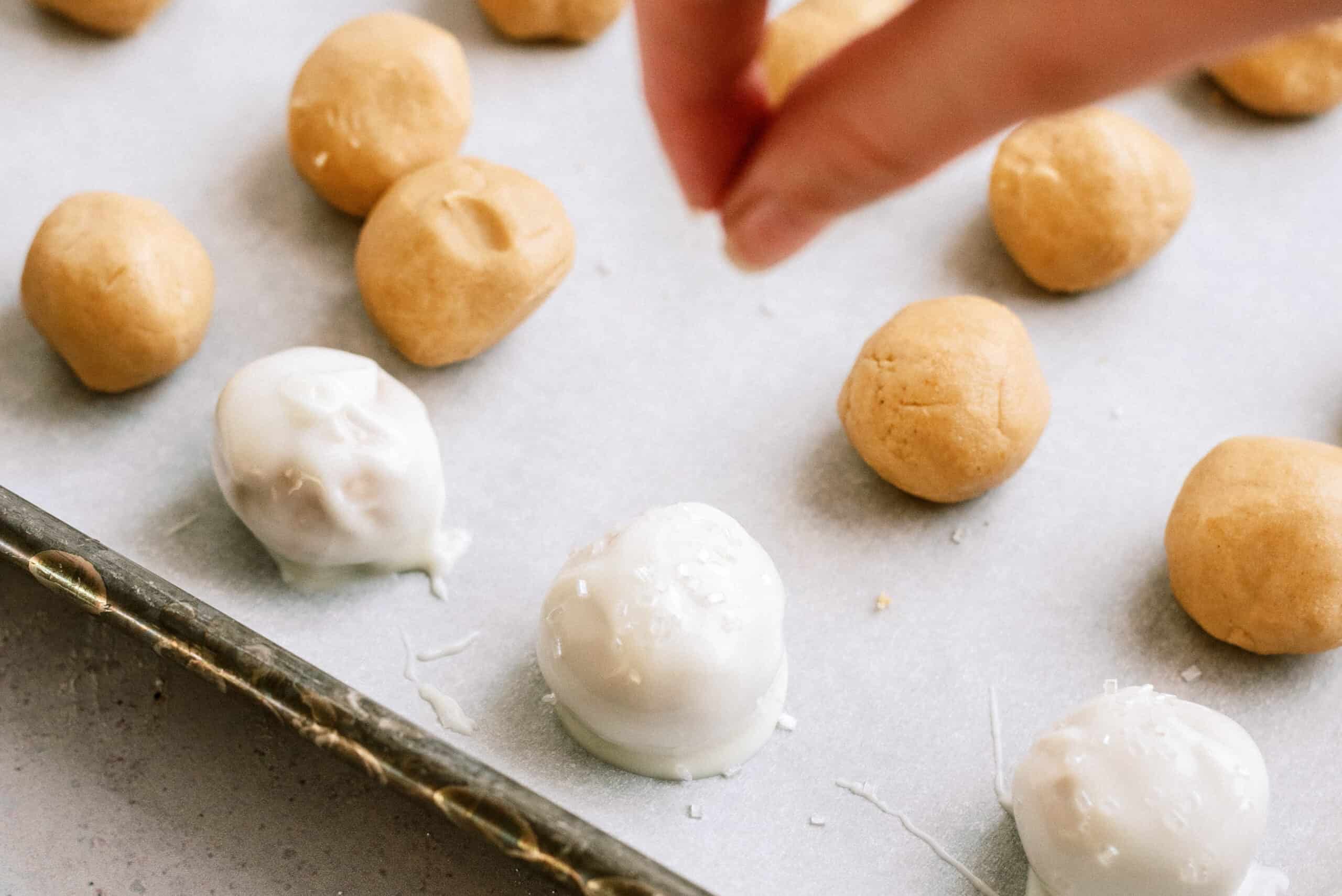 sprinkling sugar on top of peanut butter balls before white chocolate hardens