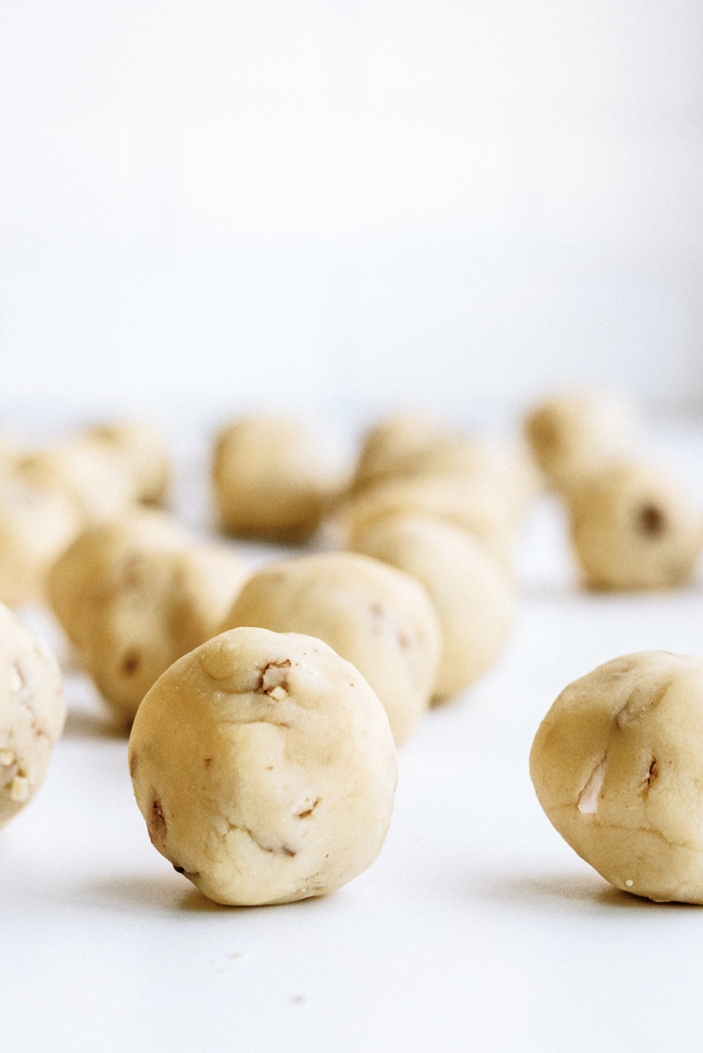 cookie dough balls on a baking sheet ready to cook