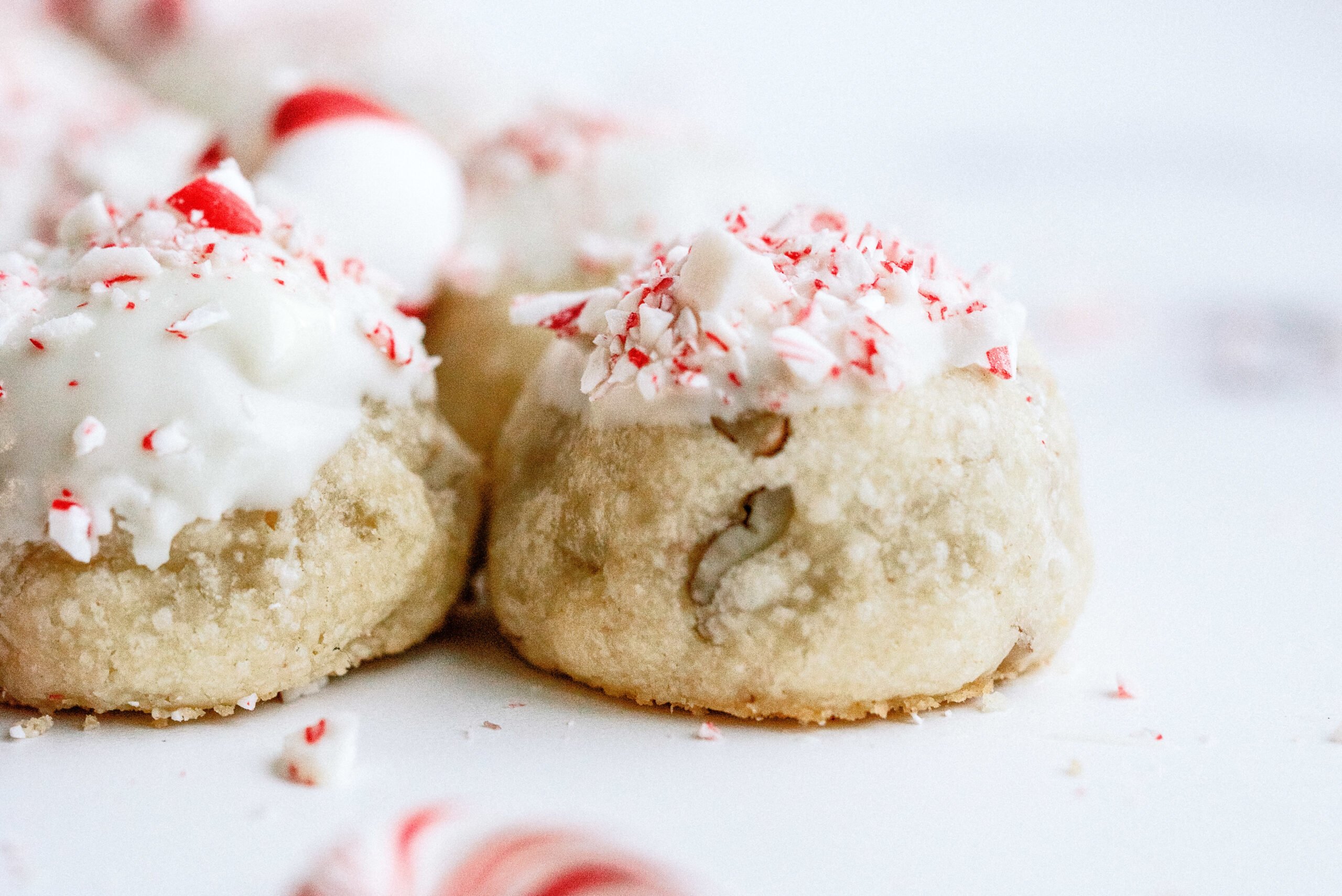 Peppermint Snowball Cookies topped with candy canes that have been crushed