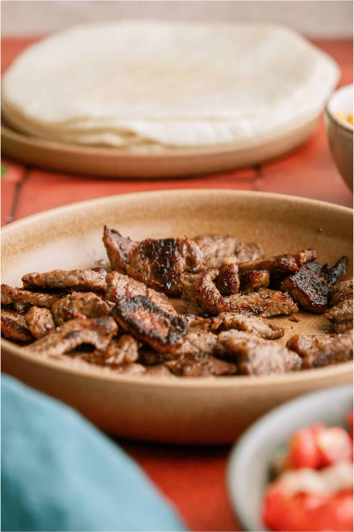 Steak strips cooked in a skillet.