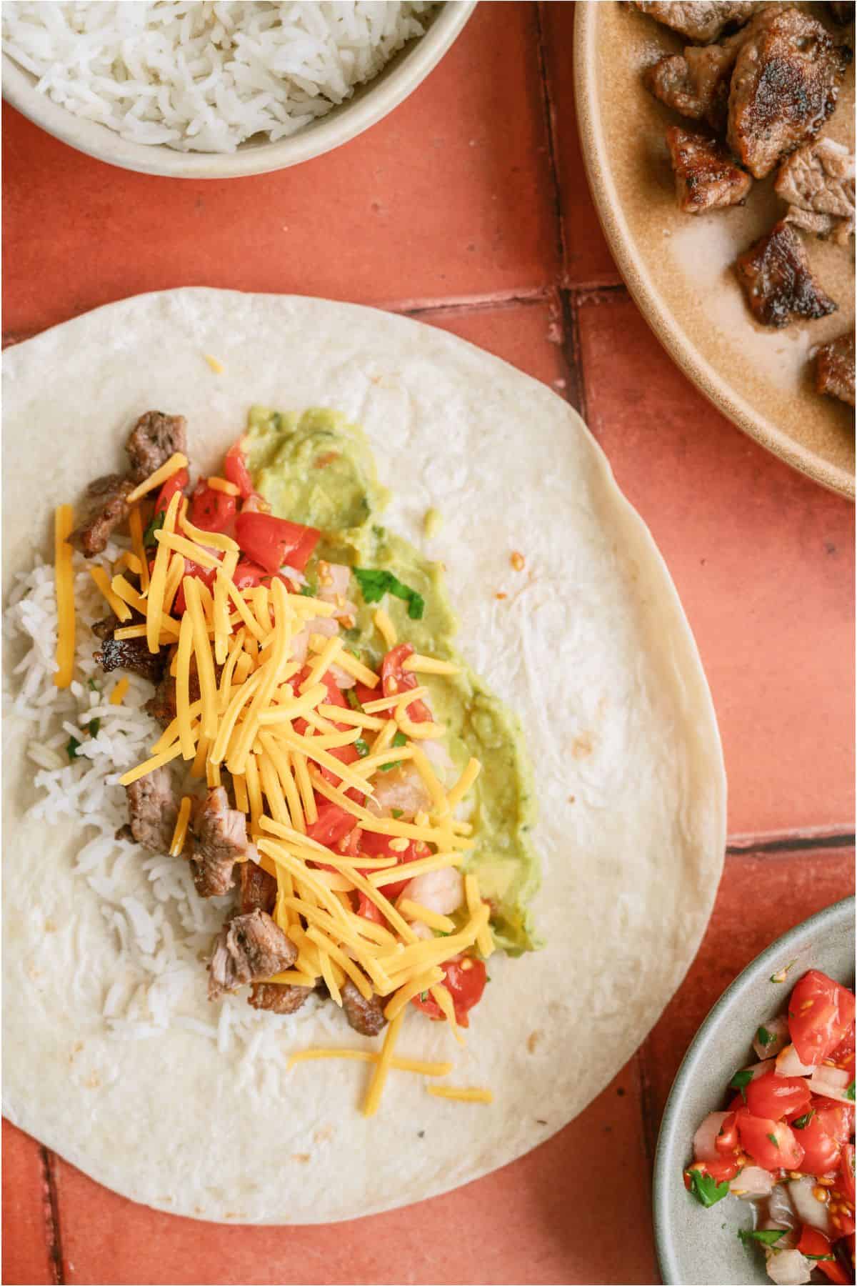 Tortilla topped with steak and other toppings.