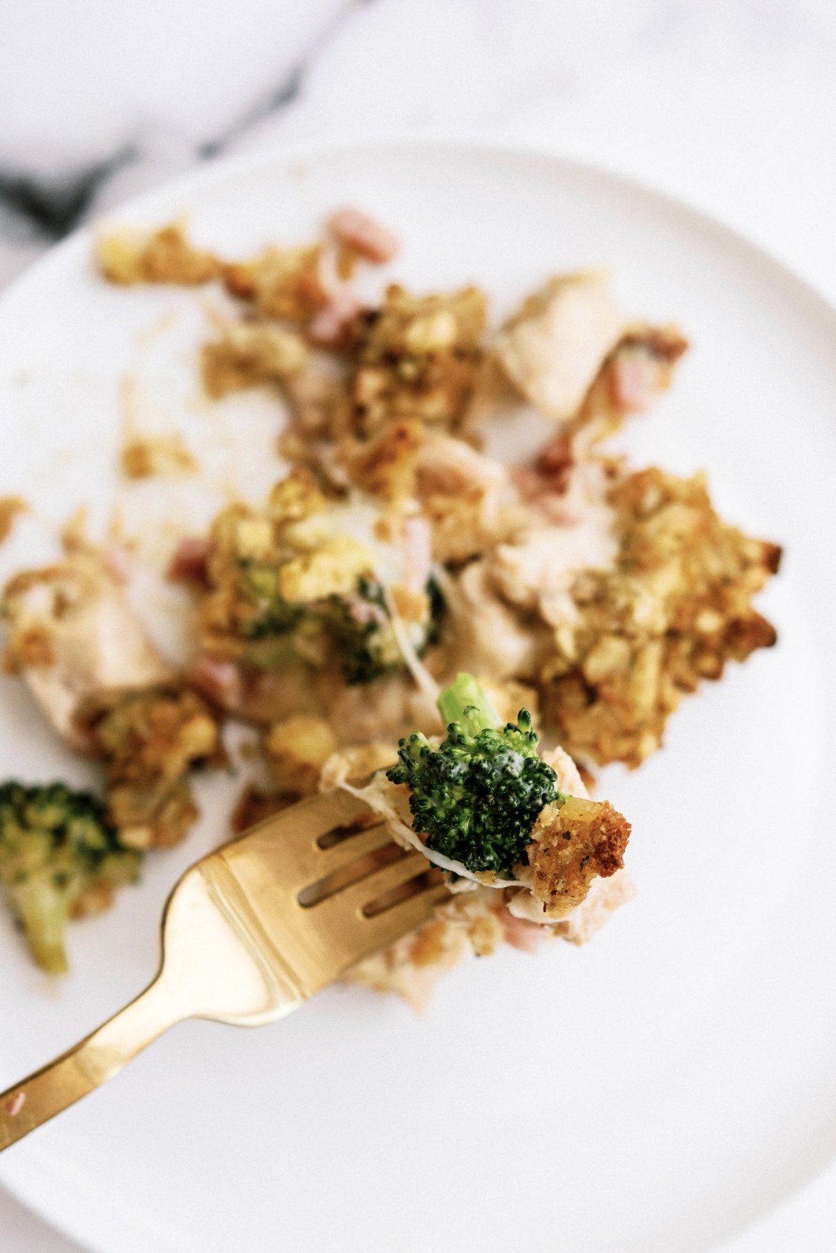 bite of chicken cordon bleu casserole with broccoli on a golden fork