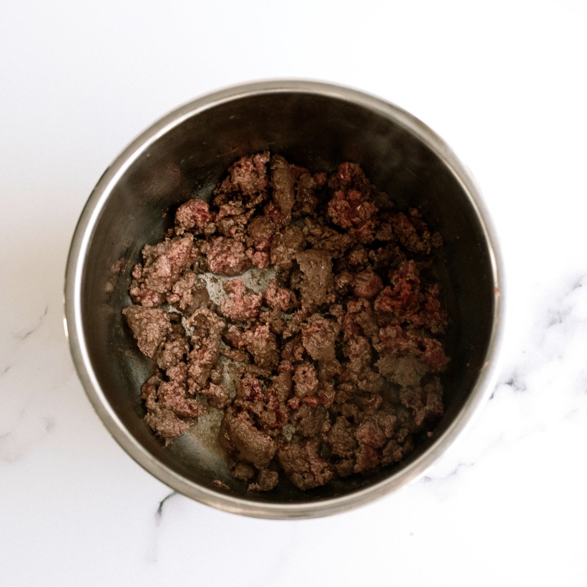 ground beef in bottom of Instant Pot partially cooked