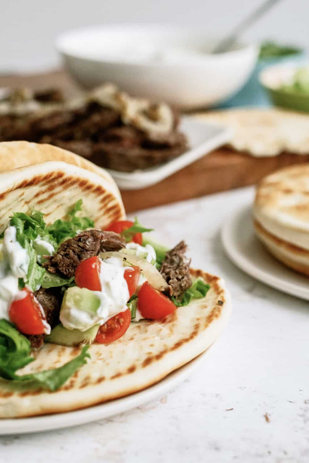 beef gyros with tomatoes and lettuce and cucumber and tzatziki