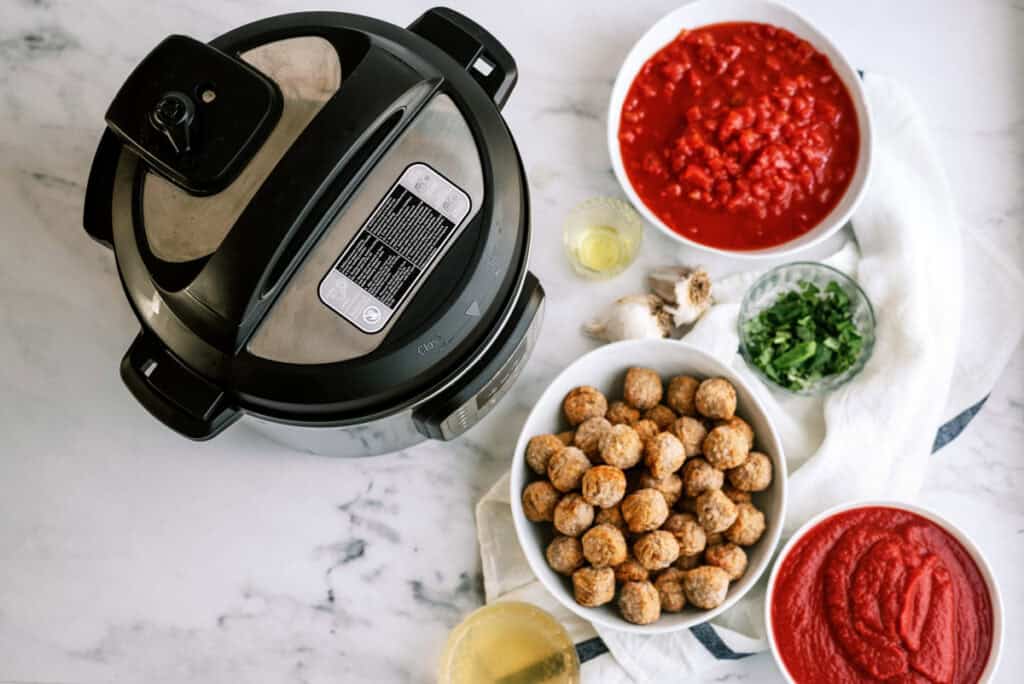 ingredients for the recipe: frozen meatballs, tomato puree, petite diced tomatoes, olive oil, minced garlic, basil, chicken broth