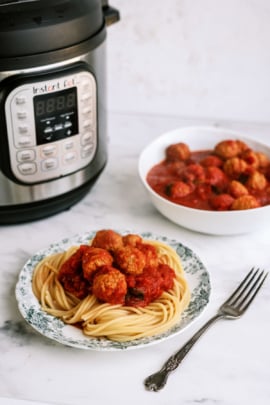 Instant Pot Italian Meatballs plated with spaghetti noodles