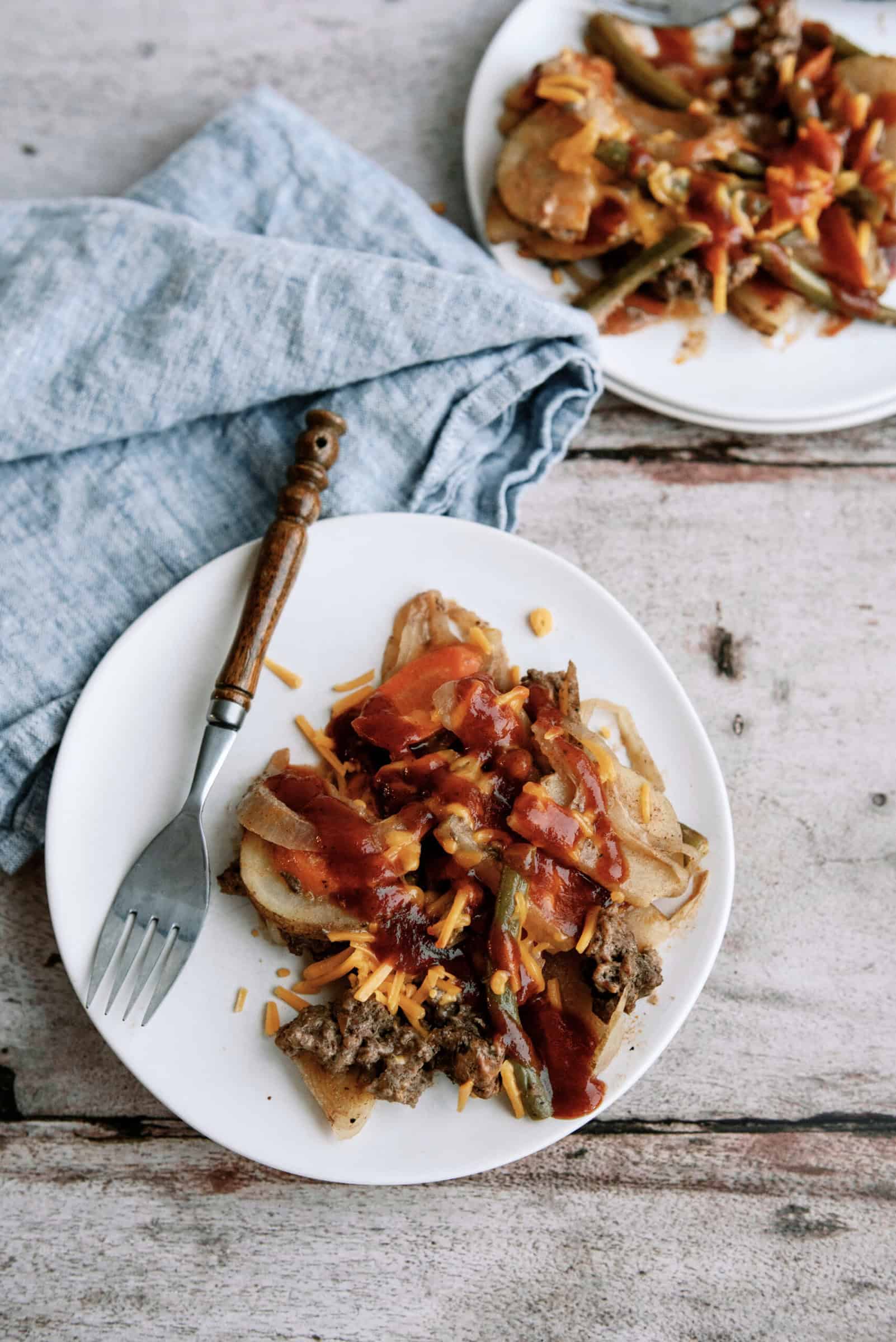 slow cooker ground beef hobo dinner topped with bbq sauce and cheese