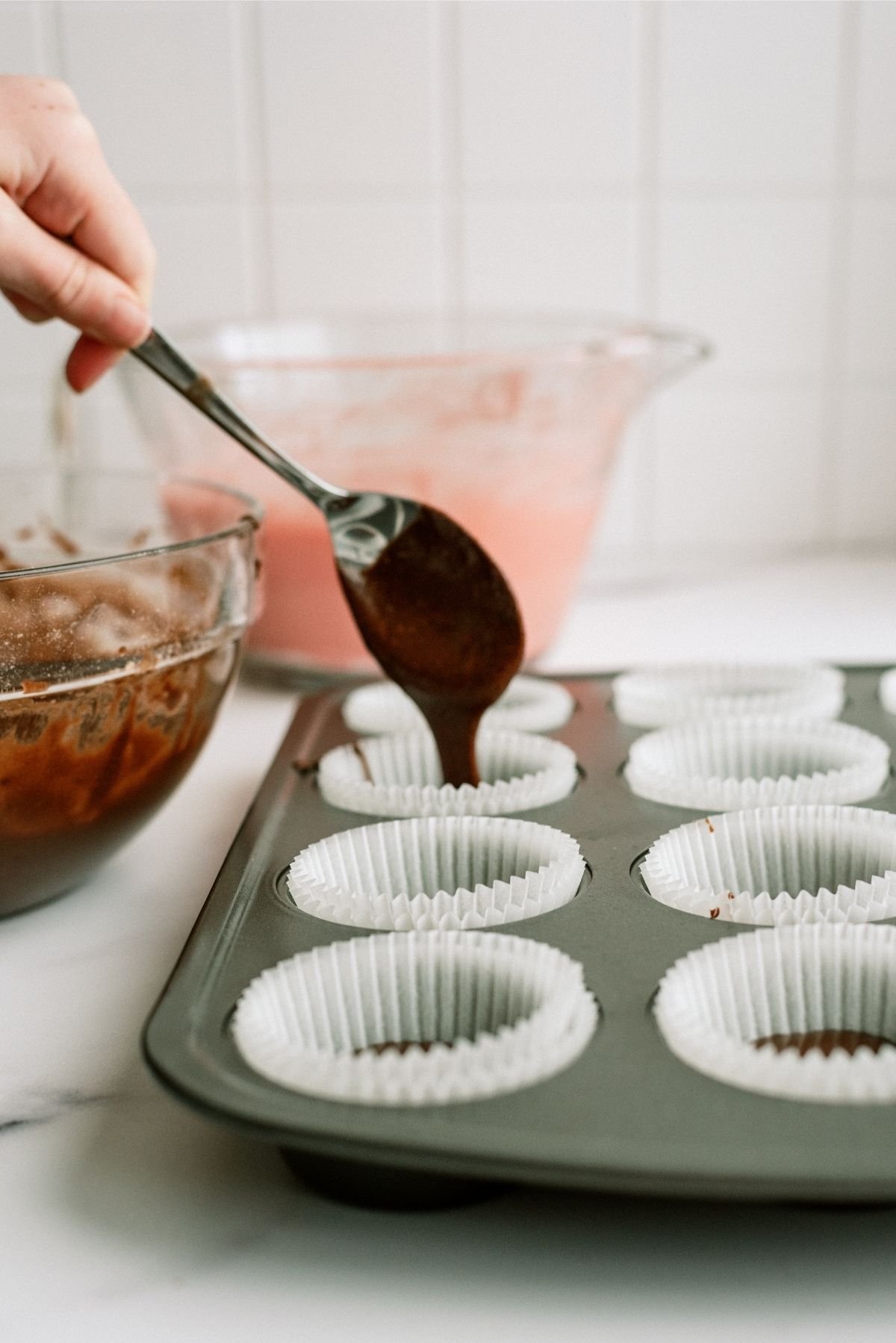 Brownie batter in muffin tin for Neapolitan Cupcakes