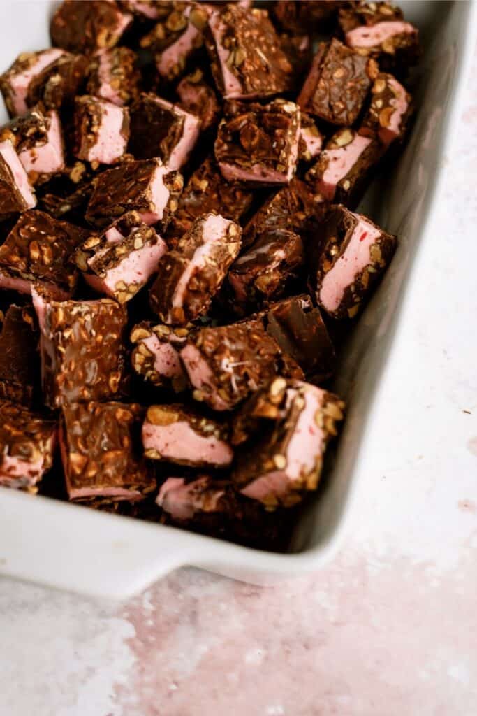 Cherry Chocolate Nut Bars cut into squares, laid in a white baking dish.