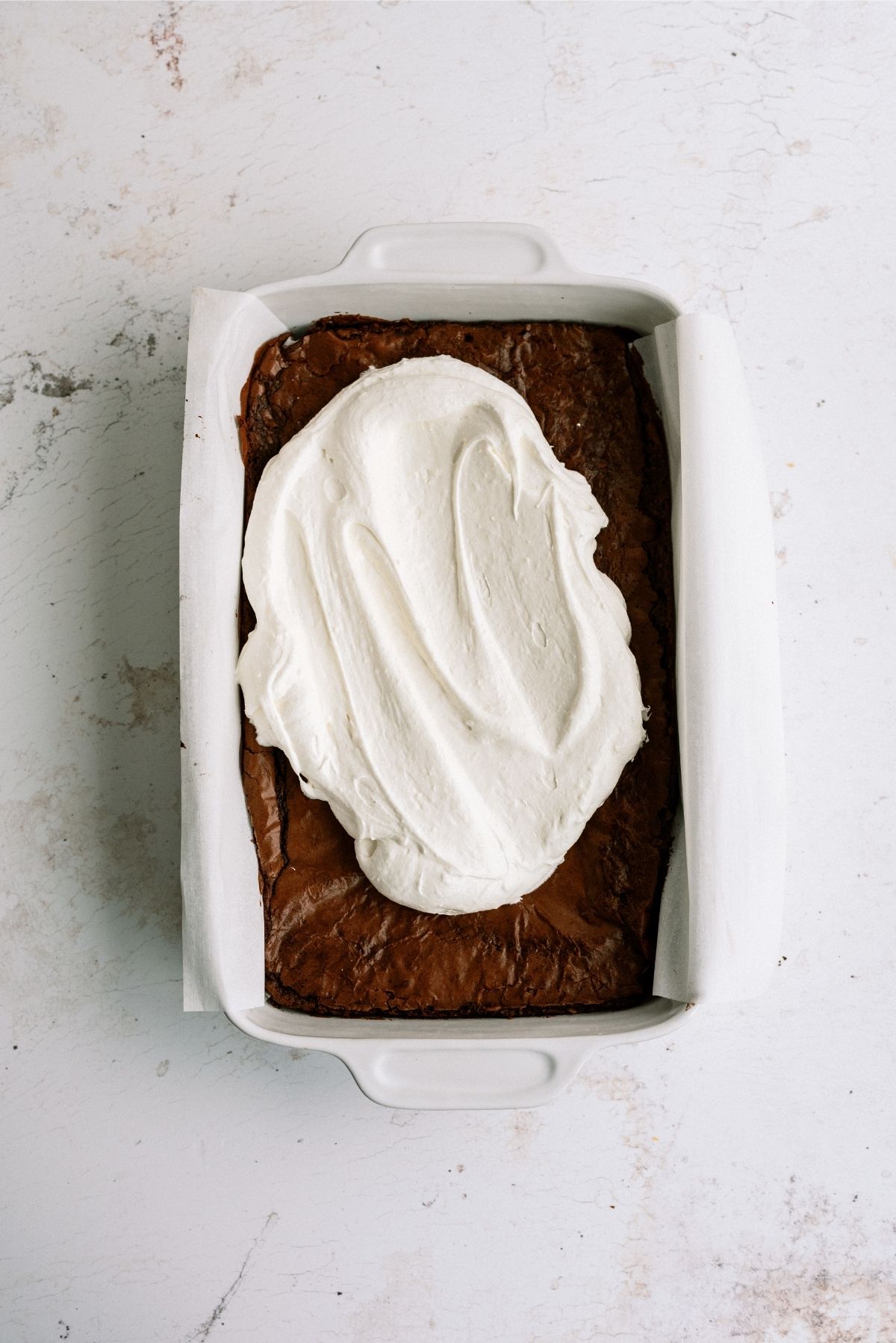 Cream cheese mixture spread over baked brownies