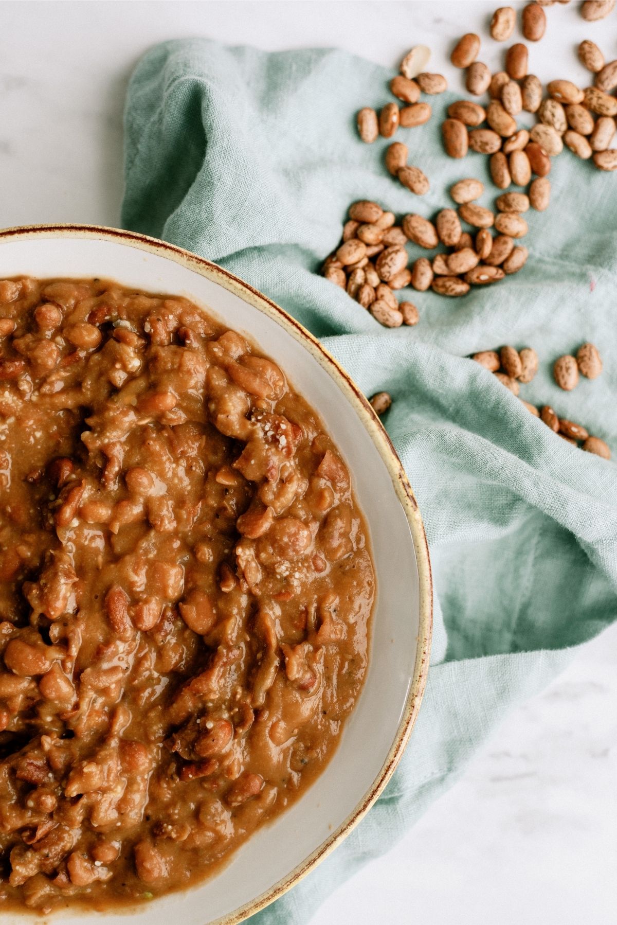 Slow Cooker refried beans in bowl with pinto beans