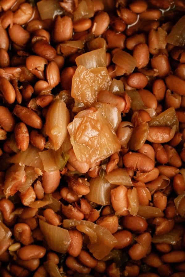 Close-up of cooked pinto beans mixed with chopped onions.