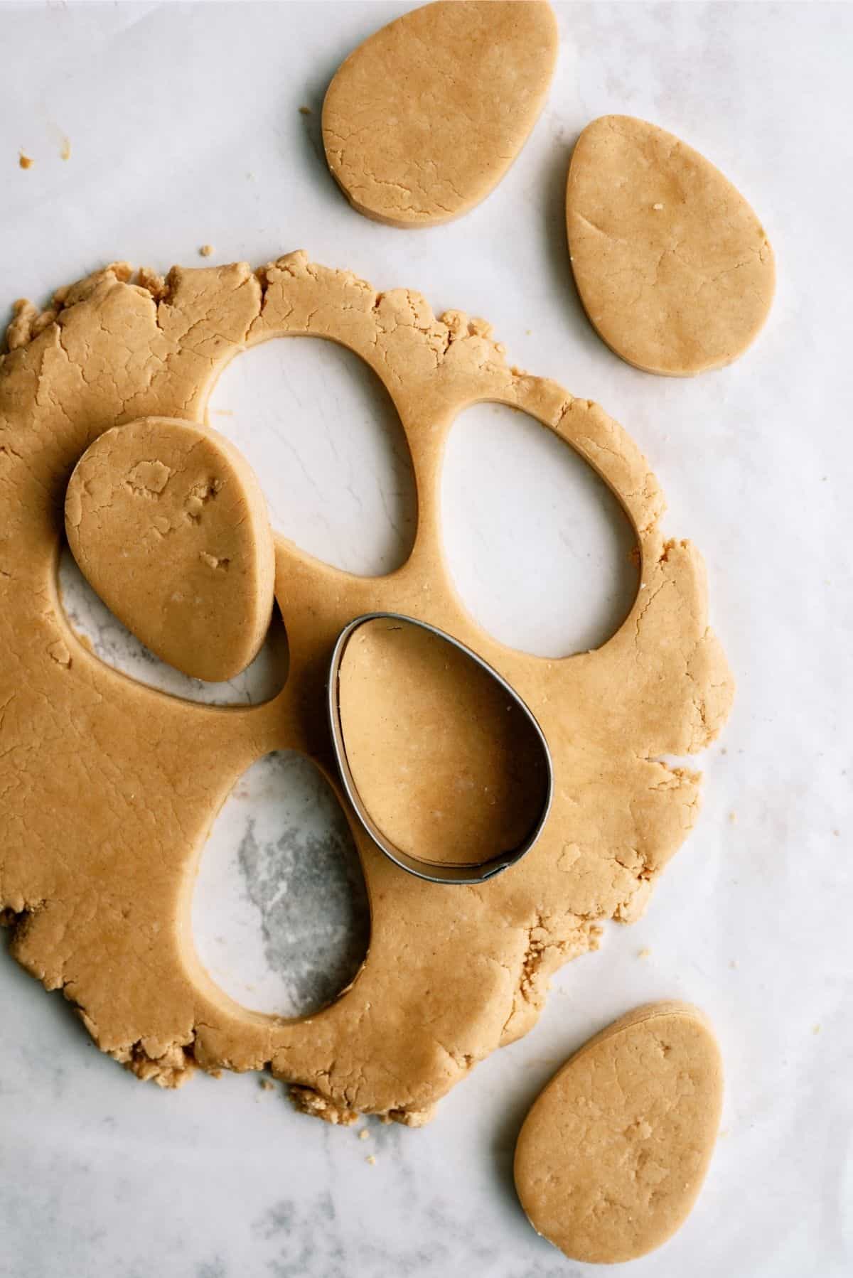 Cookie Cutter cutting out dough for Homemade Reese's Eggs in mixing bowl