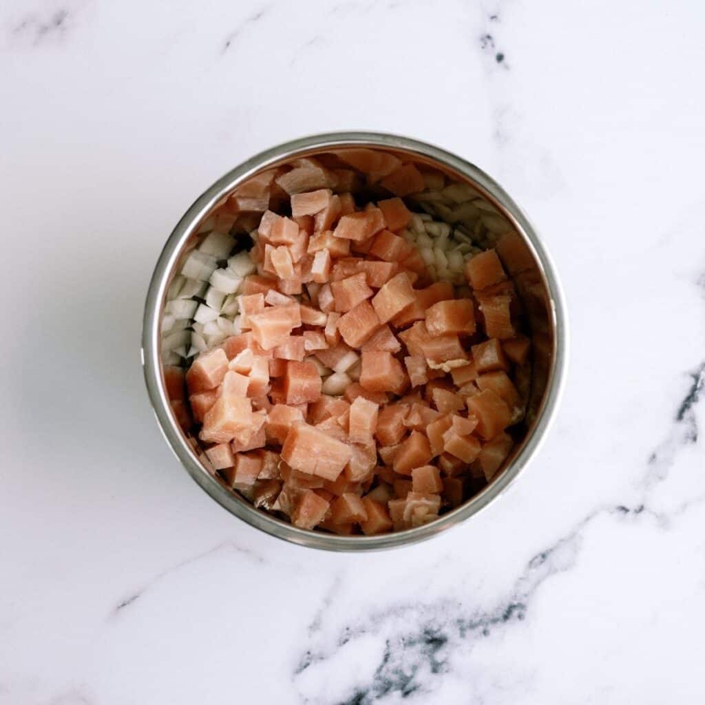 Diced chicken and onion in an Instant Pot.