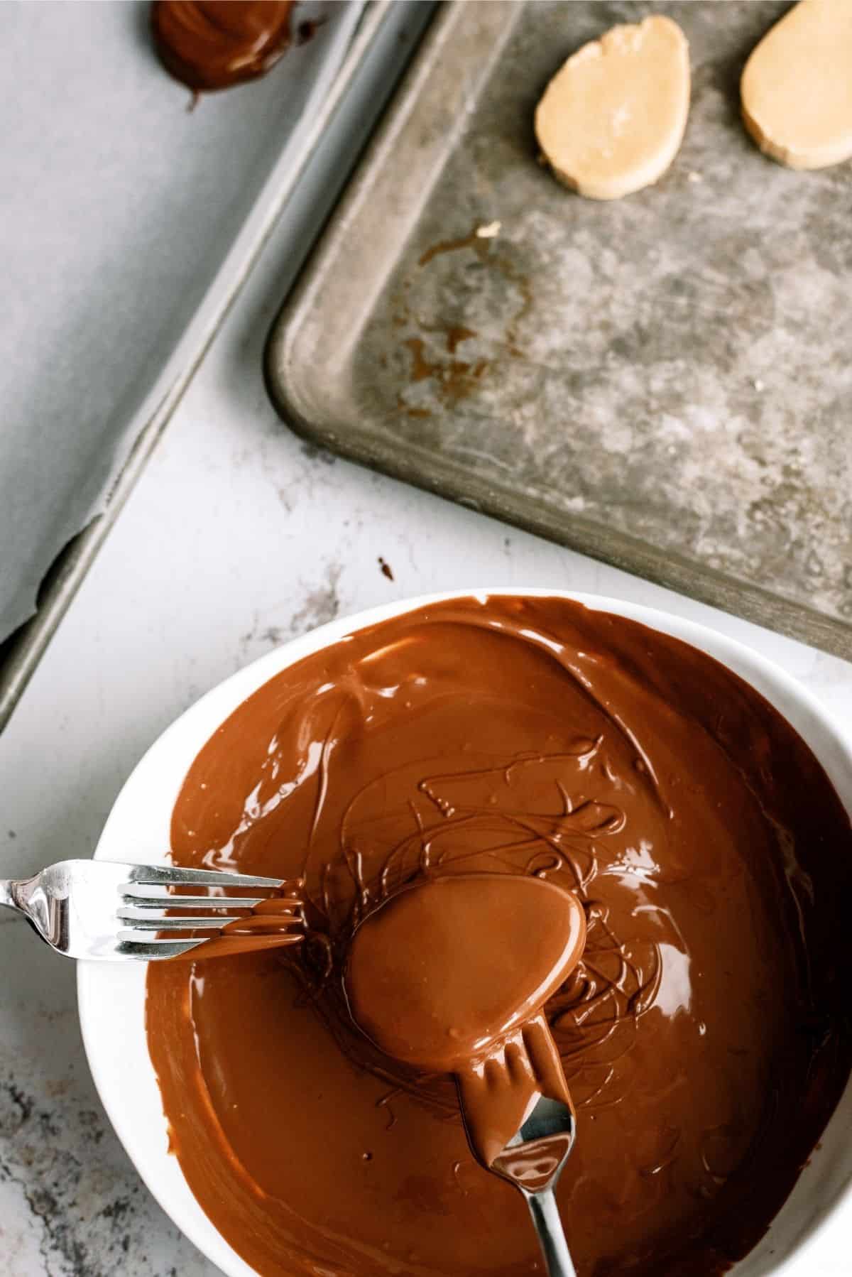 Homemade Reese's Eggs dipped in chocolate on cookie sheet