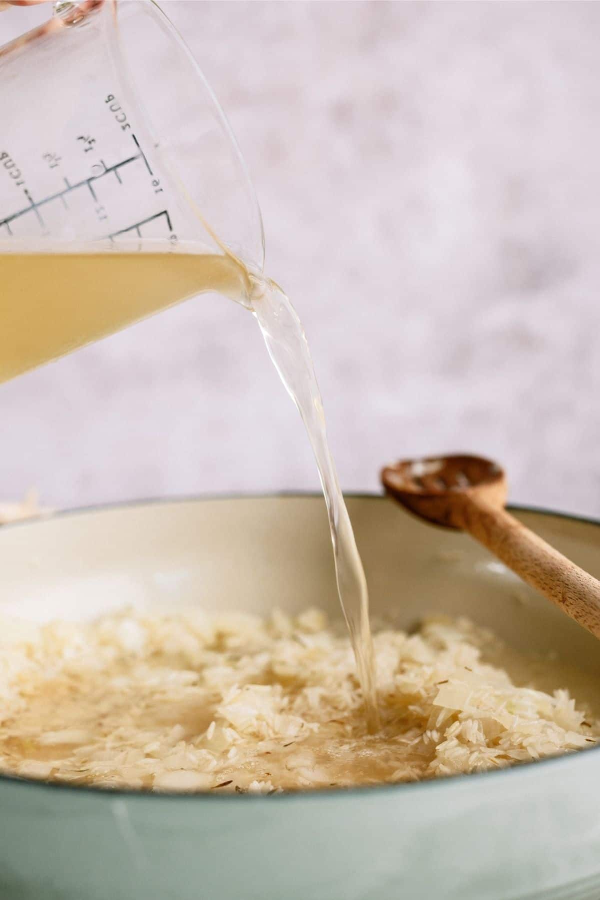 Adding Chicken Broth to pot for Creamy Chicken and Rice Casserole Skillet