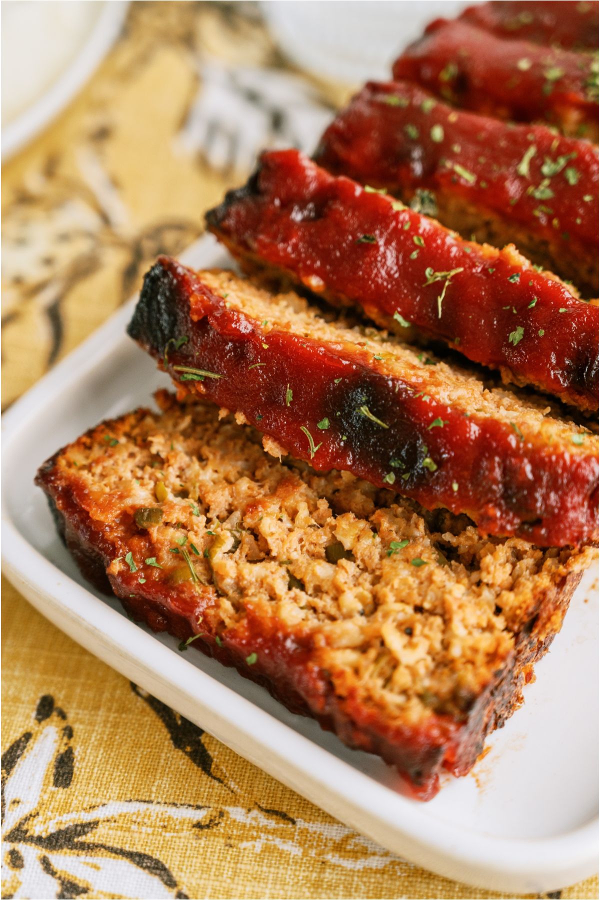 A serving platter with Easy Turkey Meatloaf sliced on it.