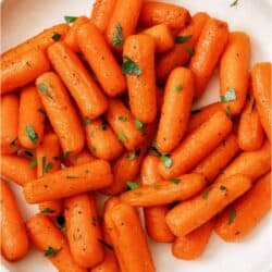 Top view of a plate of Honey Roasted Carrots topped with fresh parsley.