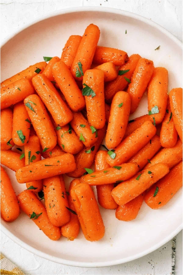 Top view of a plate of Honey Roasted Carrots topped with fresh parsley.