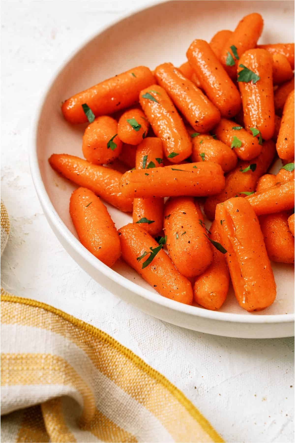 Close up of Honey Roasted Carrots on a white plate.