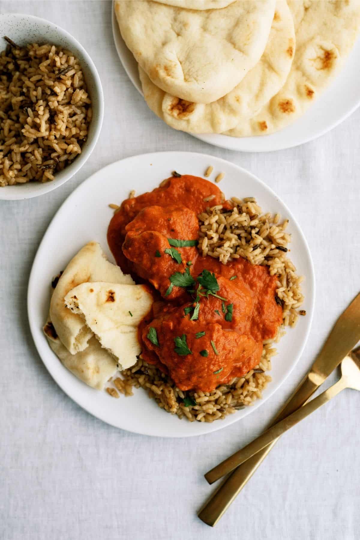 Instant Pot Butter Chicken served over rice on a white place