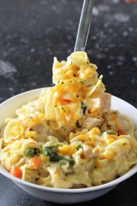 instant pot chicken and noodles being scooped out of bowl