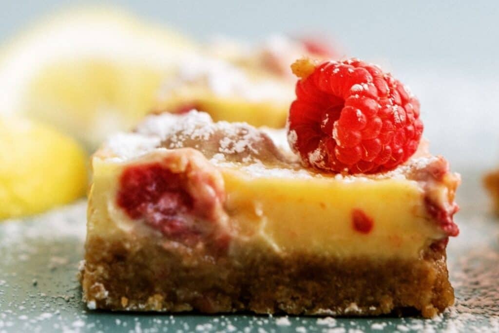 Close up of a Lemon Raspberry Bar topped with a fresh raspberry.