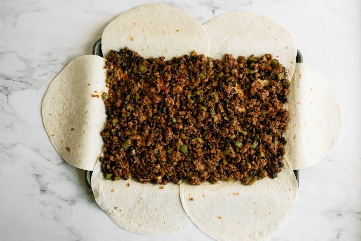 Meat mixture on top of tortillas for Sheet Pan Ground Beef Quesadillas Recipe