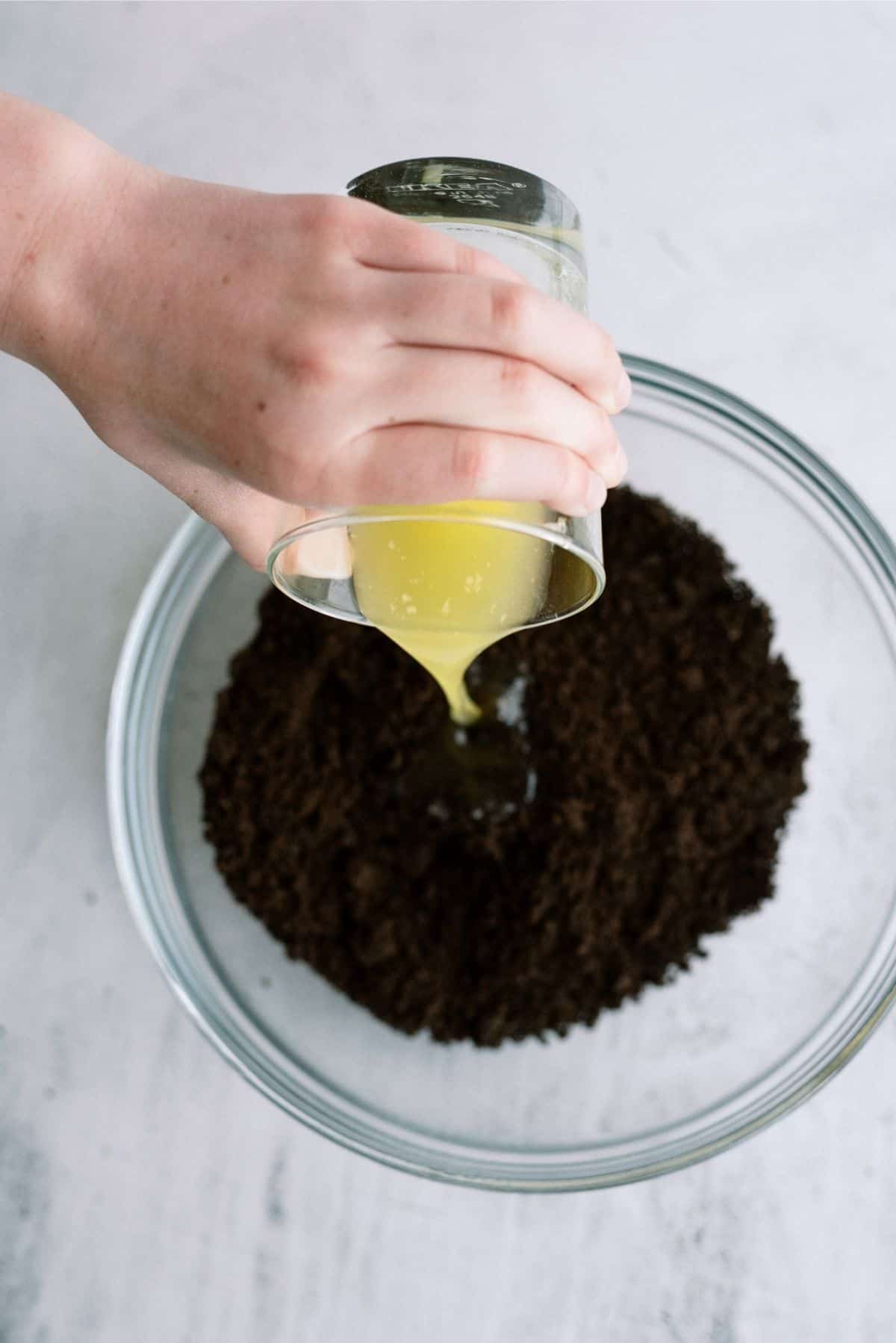 Melted Butter Poured into Oreo Cookie Crumbs