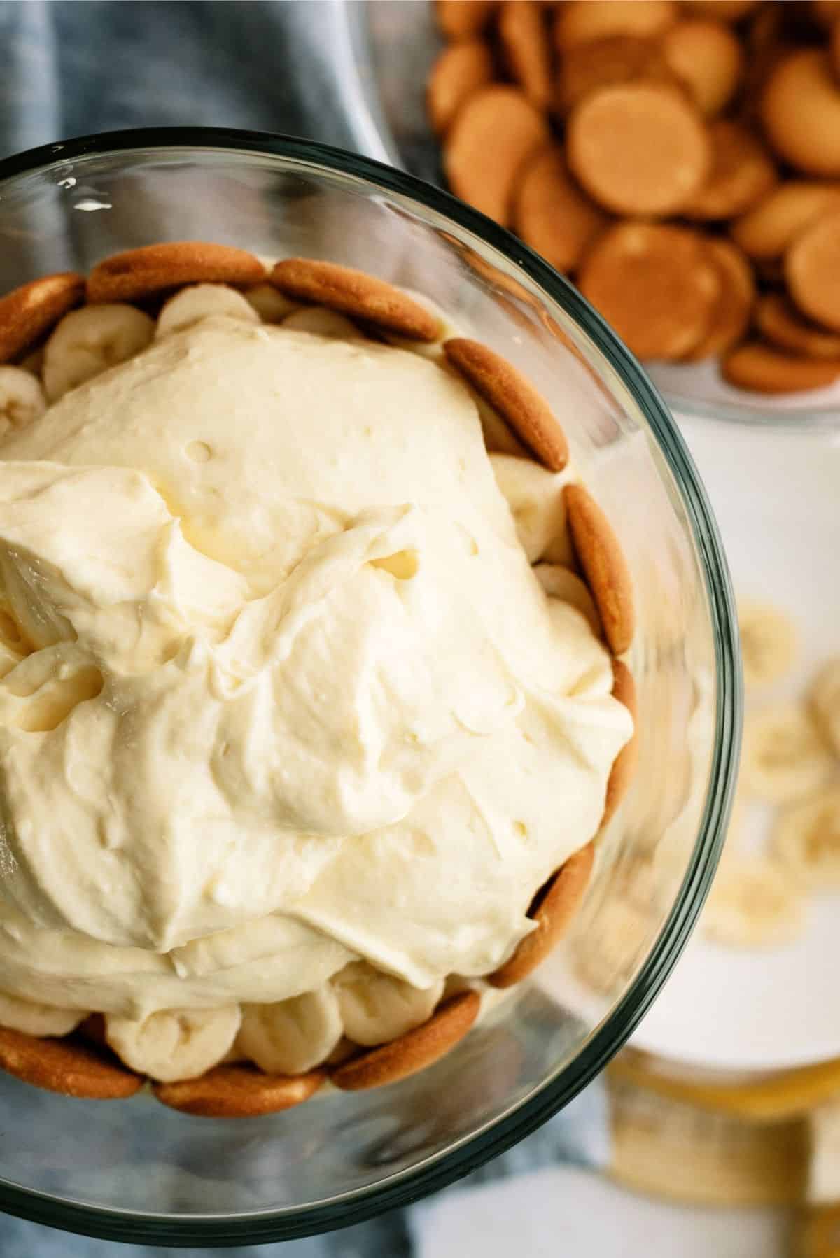 Pudding layer on top of bananas and nilla wafers in trifle dish