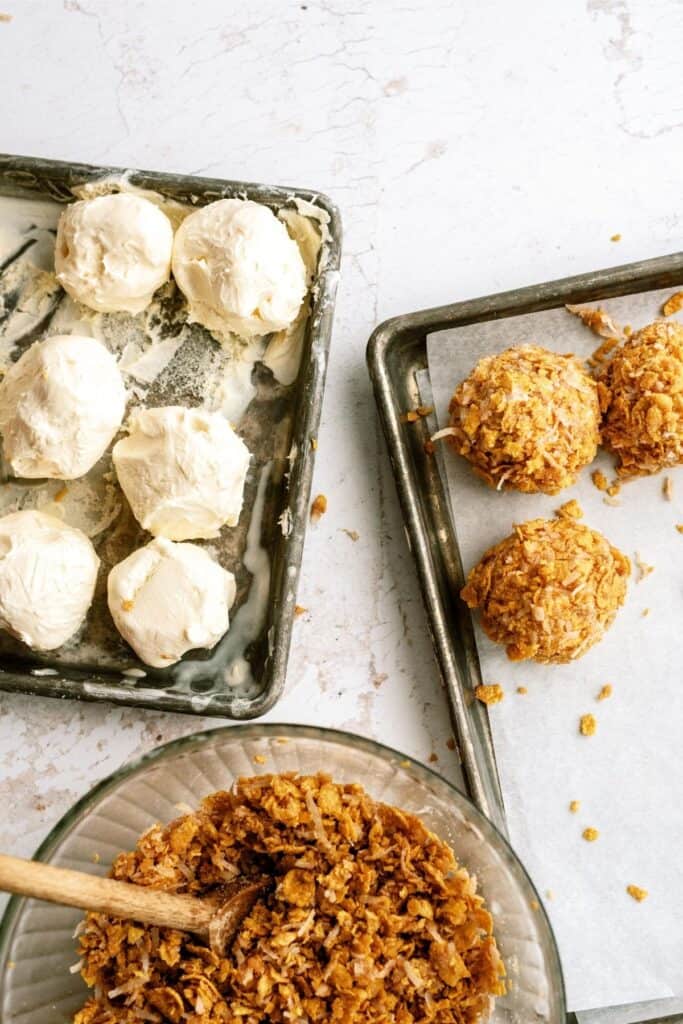 A sheet with ice cream balls, a sheet pan with Fried Ice Cream, a mixing bowl of fried ice cream topping.