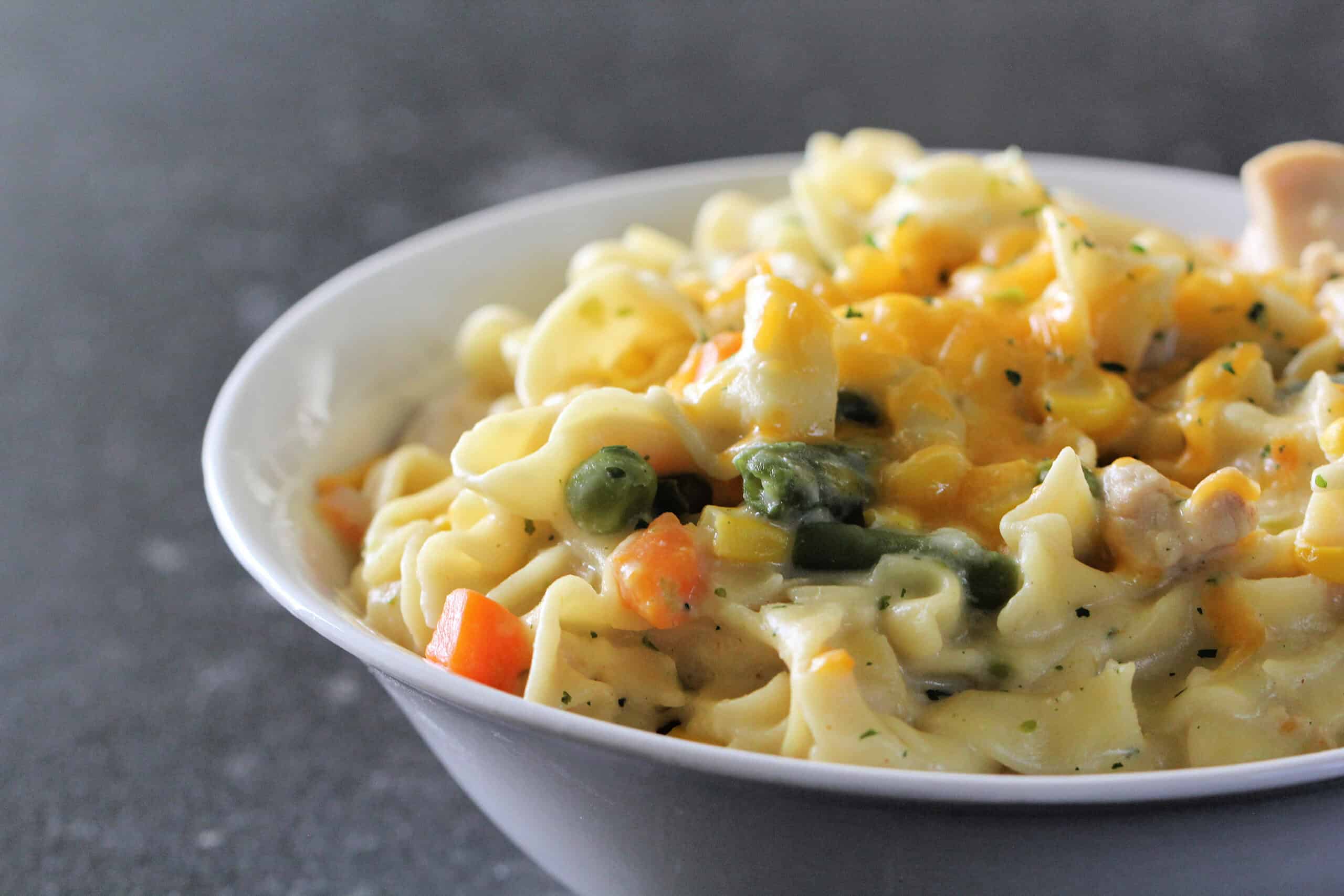 Bowl of Instant Pot Creamy Chicken and Noodles with vegetables.