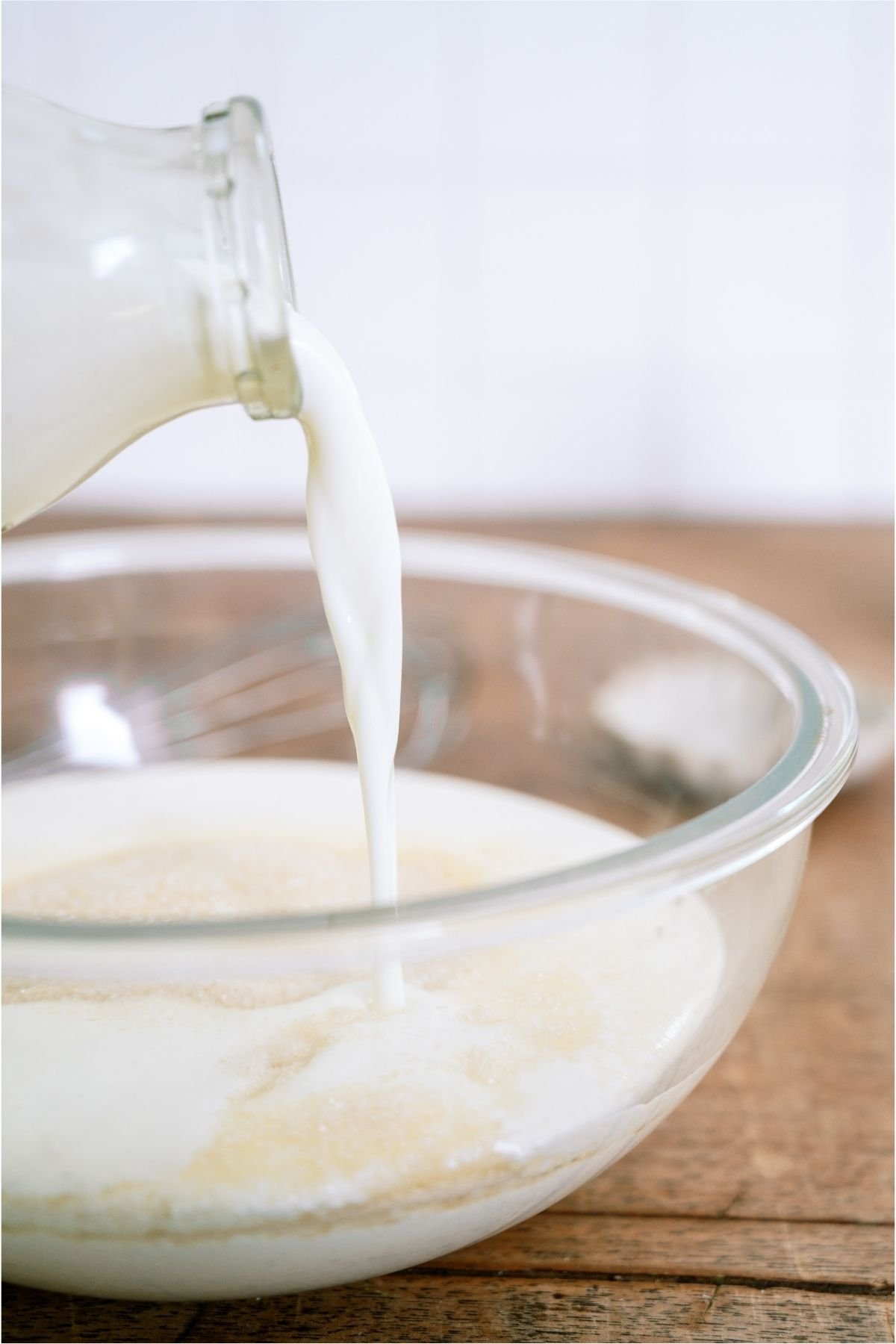 Pouring milk into a glass bowl.